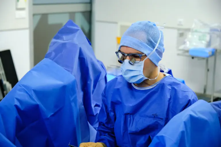 Prof. FX Madec réalisant une urétroplastie au bloc opératoire avec retransmission vidéo, illustrant étape par étape les différentes phases de la reconstruction urétrale pour le traitement des sténoses de l’urètre